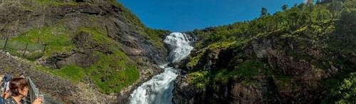 Kjosfossen waterfall, tourist looking at waterfall near Fureberget, rock faces, trees, sky, Flåm,