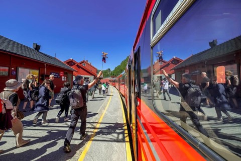 Tour guide reflected in the train window, tourists on the platform, Bergen railway station, Myrdal,