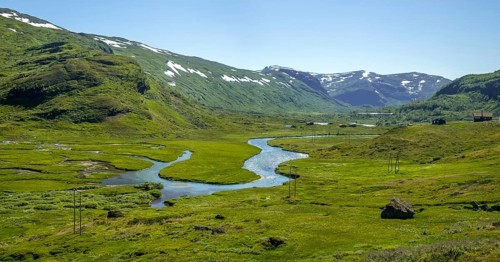 River outlets on green meadow, mountains, forest, snow peaks, sky, Myrdal, Sogn og Fjordane,