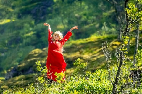Woman dressed in red is a Huldra, fairy, legendary figure, Kjosfossen waterfall, waterfall near