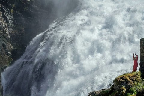 Woman dressed in red is a Huldra, fairy, legendary figure, Kjosfossen waterfall, waterfall near