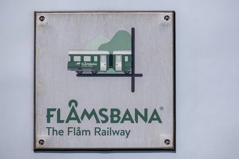 Journey on the Flam Railway, iron railway, white sign with green lettering Flåmsbana, The Flam