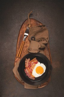 Fried egg with bacon, in a cast-iron pan, breakfast, top view, close-up, homemade, no people