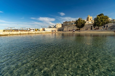 City beach Spiaggetta del Molo or Spiaggia dei Bambini and the old town centre of Otranto, Apulia,