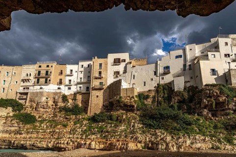 Houses above the cliffs on the town beach Spiaggia Llama Monachile in Polignano a Mare, Apulia,