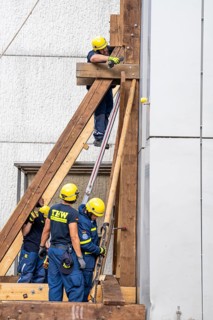 Construction of a façade support for a building in danger of collapsing, with the standard timber