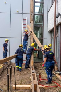 Construction of a façade support for a building in danger of collapsing, with the standard timber