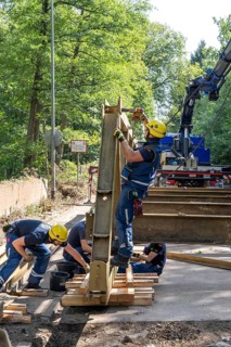 Construction of a temporary bridge over a slipped road crossing a stream, by the bridge