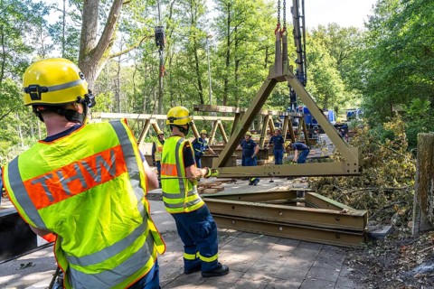 Construction of a temporary bridge over a slipped road crossing a stream, by the bridge