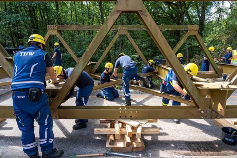 Construction of a temporary bridge over a slipped road crossing a stream, by the bridge