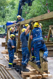 Construction of a temporary bridge over a slipped road crossing a stream, by the bridge