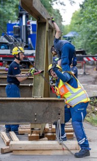 Construction of a temporary bridge over a slipped road crossing a stream, by the bridge