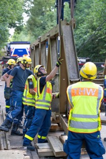 Construction of a temporary bridge over a slipped road crossing a stream, by the bridge