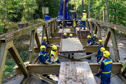 Construction of a temporary bridge over a slipped road crossing a stream, by the bridge