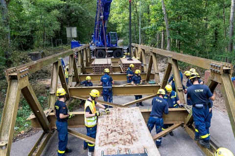 Construction of a temporary bridge over a slipped road crossing a stream, by the bridge
