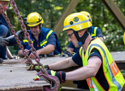 Construction of a temporary bridge over a slipped road crossing a stream, by the bridge