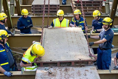 Construction of a temporary bridge over a slipped road crossing a stream, by the bridge