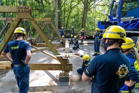 Construction of a temporary bridge over a slipped road crossing a stream, by the bridge