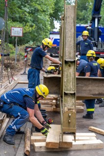 Construction of a temporary bridge over a slipped road crossing a stream, by the bridge
