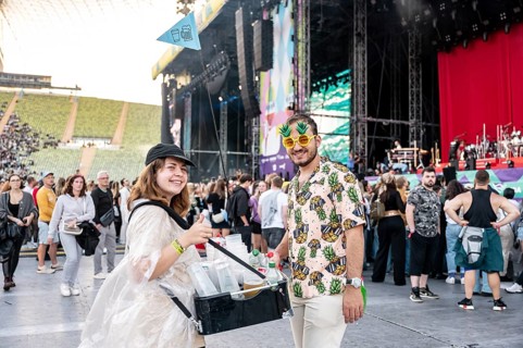 Man in pineapple sunglasses and pineapple shirt with female drinks vendor at Superbloom Festival,