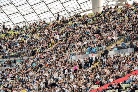 Festival visitors sitting in the stands in the Olympic Stadium at the Superbloom Festival, Day 1 in