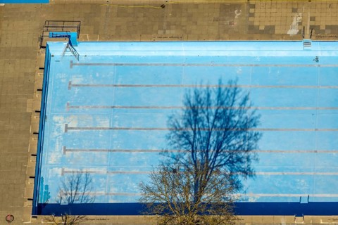 Aerial view, outdoor and indoor swimming pool, tree reflected in the pool, Meschede town, Meschede,