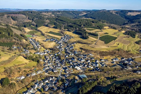 Aerial view, residential area town centre with St. Katharina Catholic Church, wooded area hilly