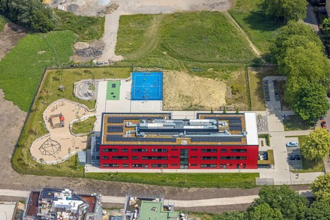 Aerial view, community primary school Schule am Schloss with red facade, roof with solar panels,