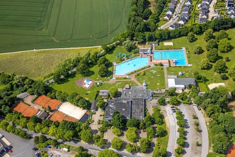 Aerial view, outdoor and indoor swimming pool HeljensBAD with sunbathing lawn, tennis facility of
