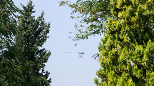 Türkiye special operations police hang from a helicopter with ropes, carrying weapons and unfurling