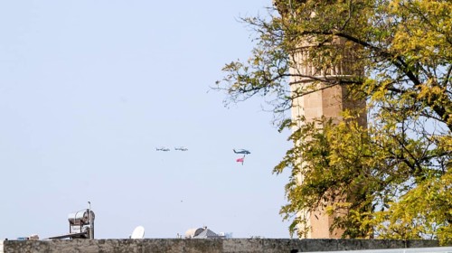 Türkiye special operations police hang from a helicopter with ropes, carrying weapons and unfurling