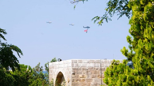 Türkiye special operations police hang from a helicopter with ropes, carrying weapons and unfurling