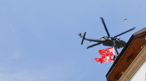 Türkiye special operations police hang from a helicopter with ropes, carrying weapons and unfurling
