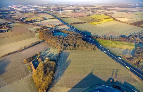 Aerial view, motorway A2, meadows and fields with wind turbines, distant view to the industrial