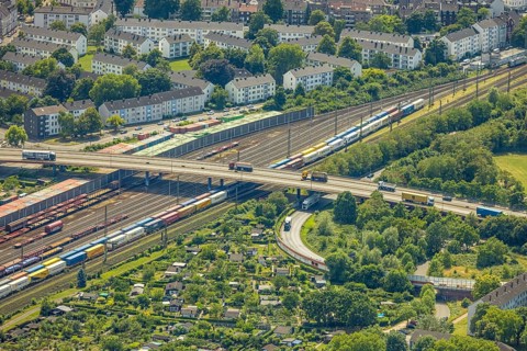 Aerial view, railway line with container site and bridge Friedrich-Ebert-Straße with curved road