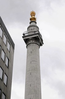 Corinthian Column in Warwick Court, London, Column with gold decorated top in front of clear blue