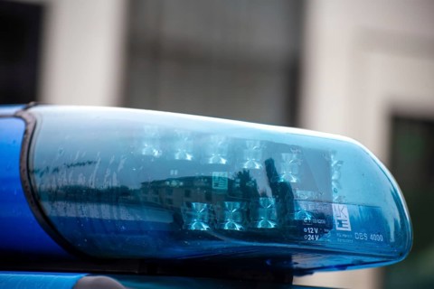 Symbolic image of a police operation: close-up of a flashing blue light on a police car