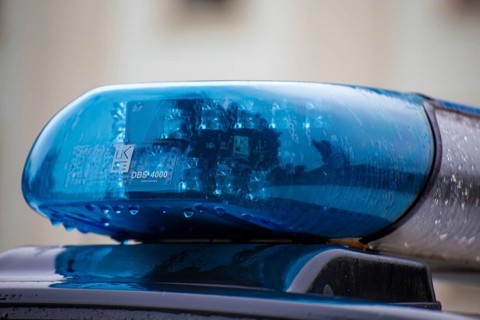 Symbolic image of a police operation: close-up of a flashing blue light on a police car