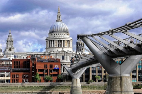 St Paul's Cathedral next to the Millennium Bridge under a dramatic sky, London, England, United