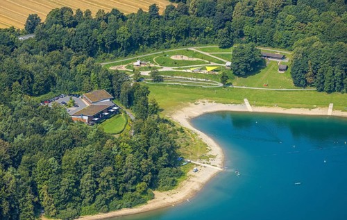 Aerial view, H1 am See Restaurant with green roof, sandy beach and adventure playground Piraten