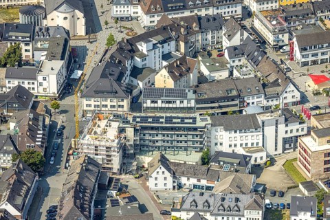 Aerial view, construction site with construction crane and new residential building on the corner