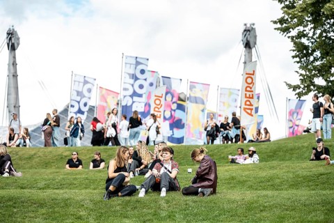Visitors relaxing in a meadow at the Superbloom Festival, Day 1 in the Olympic Park, Munich,