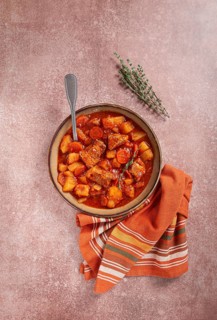 Meat goulash with potatoes and carrots, sweet peppers, in a saucepan, top view, traditional