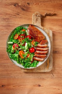 Delicious grilled duck breast served with fresh garden salad and cherry tomatoes at a rustic dining
