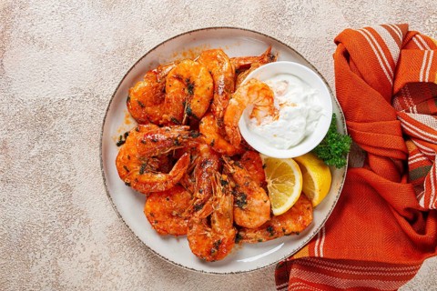Fried white-footed shrimp, tiger prawns vannamey, on a plate, with lemon and herbs, no people