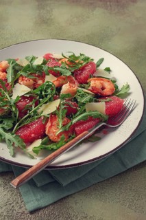 Fresh shrimp salad with arugula, grapefruit, and parmesan served in a bowl