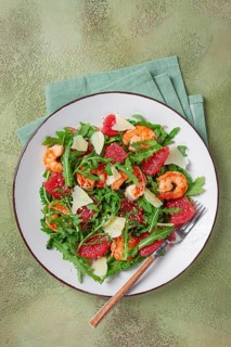 Fresh shrimp salad with arugula, grapefruit, and parmesan served in a bowl