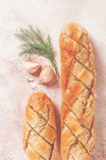 Freshly baked garlic bread with herbs and garlic on a light countertop