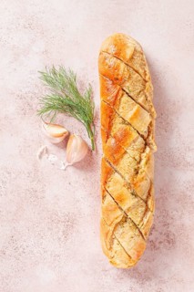 Freshly baked garlic bread with herbs and garlic on a light countertop