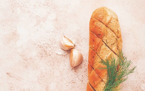 Freshly baked garlic bread with herbs and garlic on a light countertop
